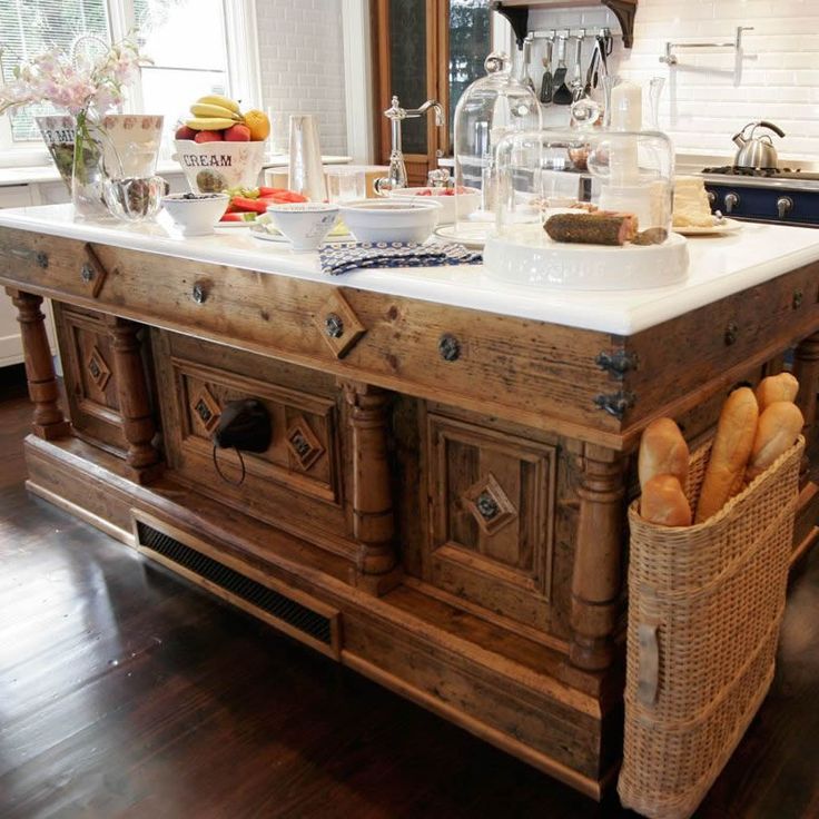 a kitchen island made out of wood with baskets on the top and bread in front