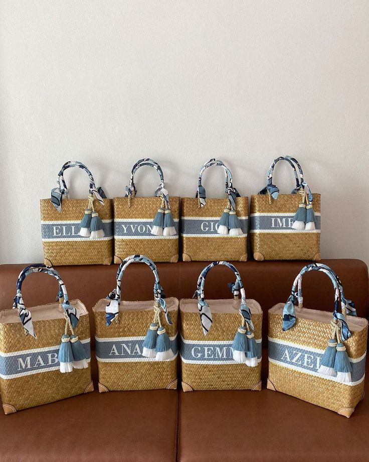 six baskets are arranged on a couch with the names of their respective people in blue and white