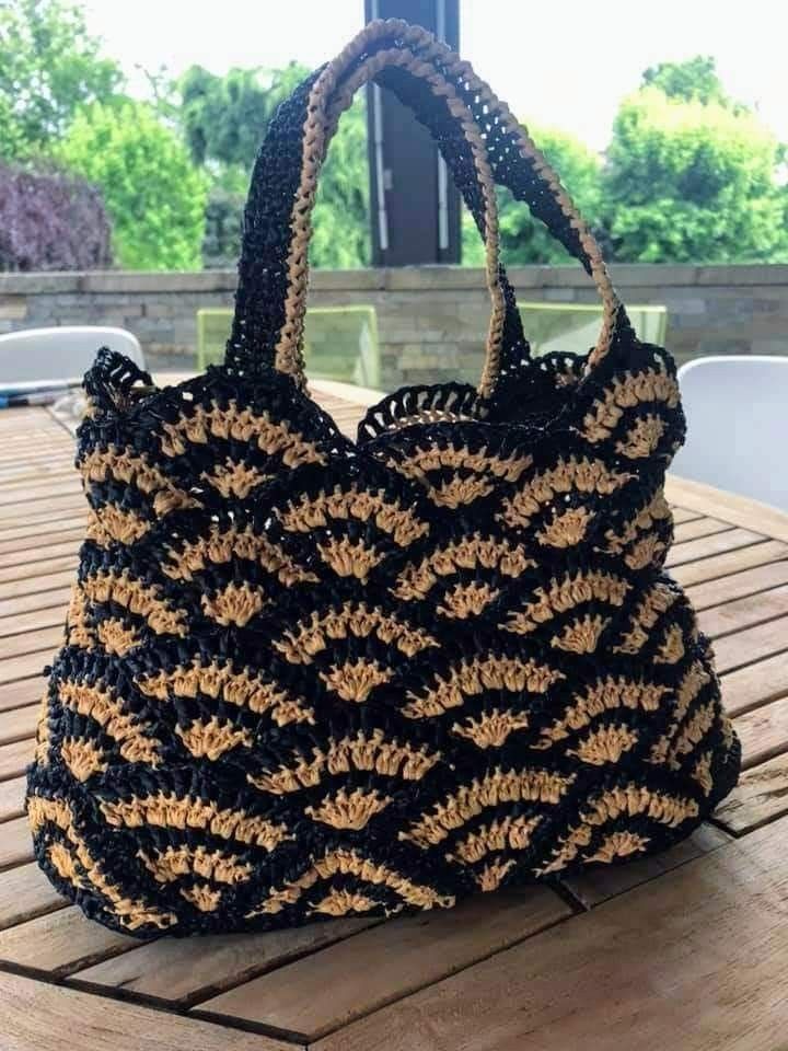 a crocheted bag sitting on top of a wooden table