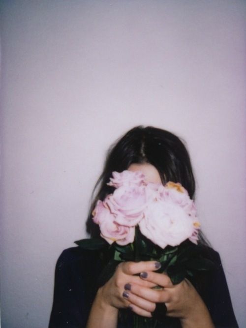 a woman holding pink roses in her hands