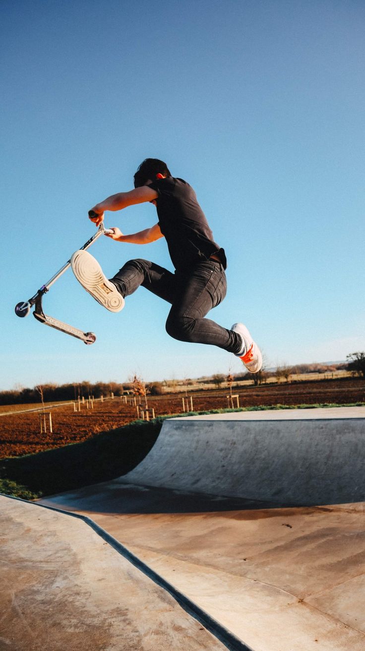 a man flying through the air while riding a skateboard at a skateboarding park