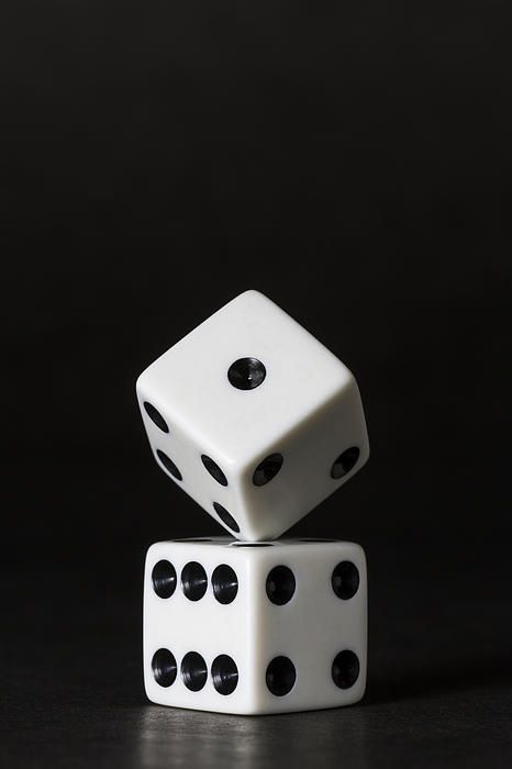 two dices stacked on top of each other in the middle of a black background