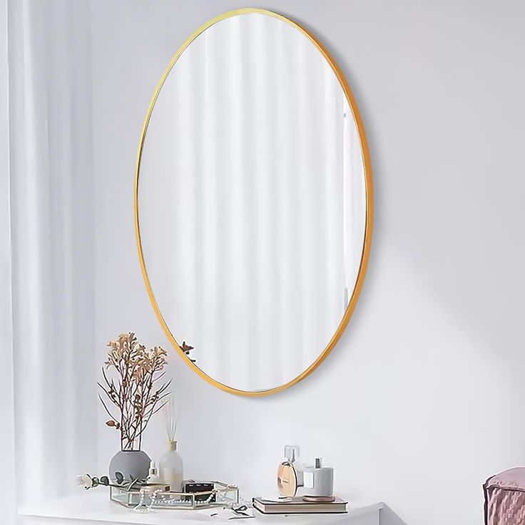 a round mirror on the wall above a white vanity with a vase and other items