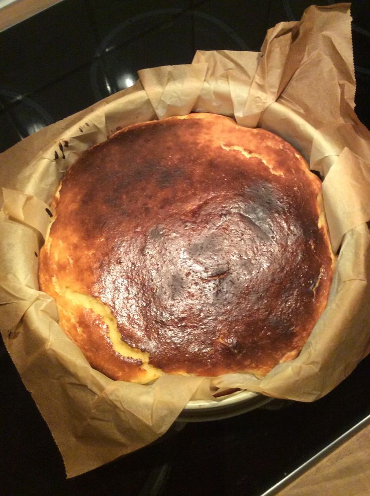 a baked bread in a paper wrapper on top of an oven burner,