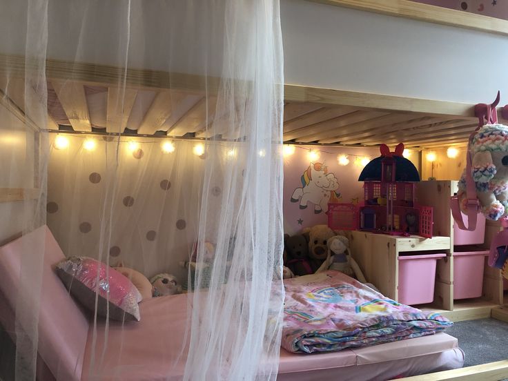 a bedroom with pink furniture and lights on the ceiling