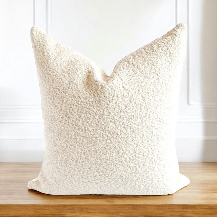 a white pillow sitting on top of a wooden table