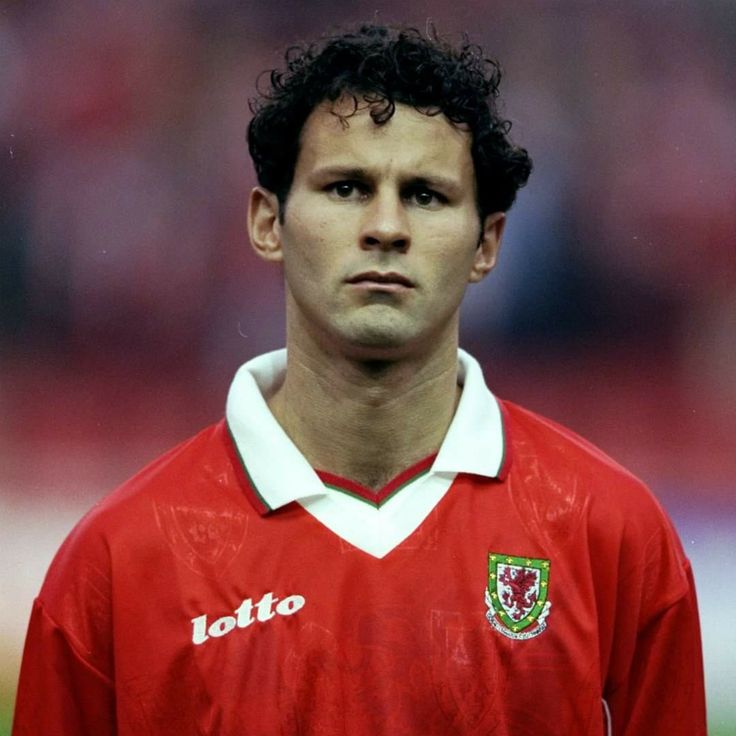 a young man in a red shirt is looking at the camera with an intense look on his face