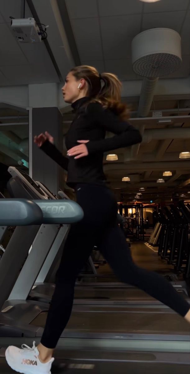 a woman running on a treadmill in a gym