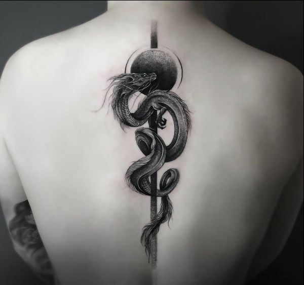 a woman's back with a snake tattoo on it