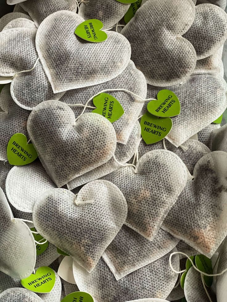 many heart shaped candies with green tags on them