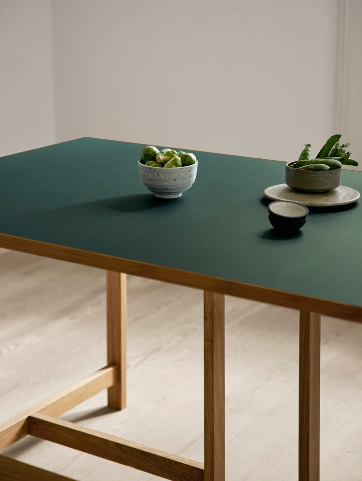 two bowls with plants sit on top of a table