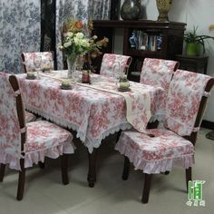 a dining room table and chairs covered in pink floral fabric with white ruffles