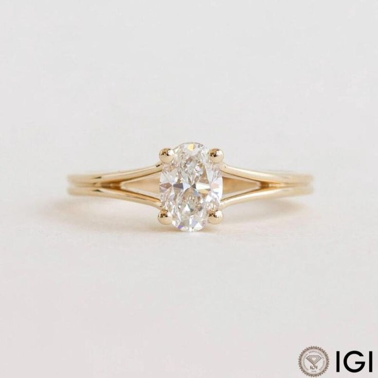 a yellow gold engagement ring with an oval cut diamond in the center, on a white background