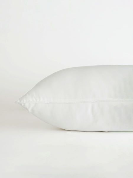 a white pillow sitting on top of a bed