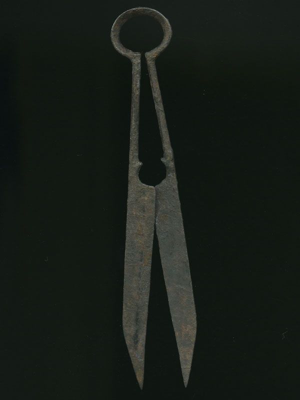 an old pair of scissors sitting on top of a black table next to each other