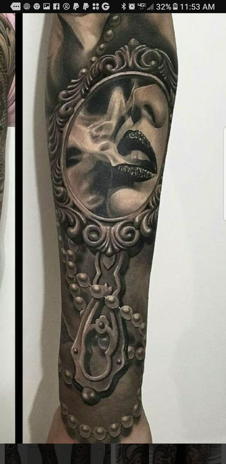 a man's leg with tattoos on it and an image of a woman in a mirror