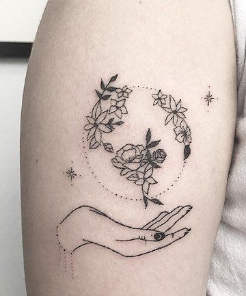 a woman's arm with a tattoo on it that has flowers in the middle