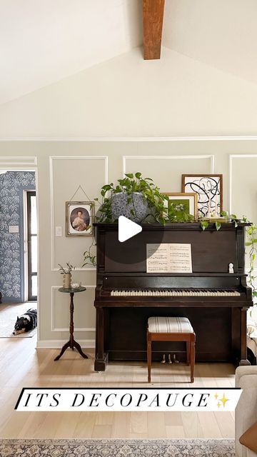 a living room filled with furniture and a piano in front of a wall that says it's decopage