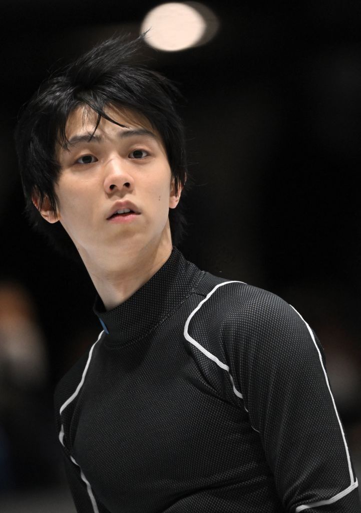 a young man with black hair is looking at the camera while wearing a black turtle neck sweater