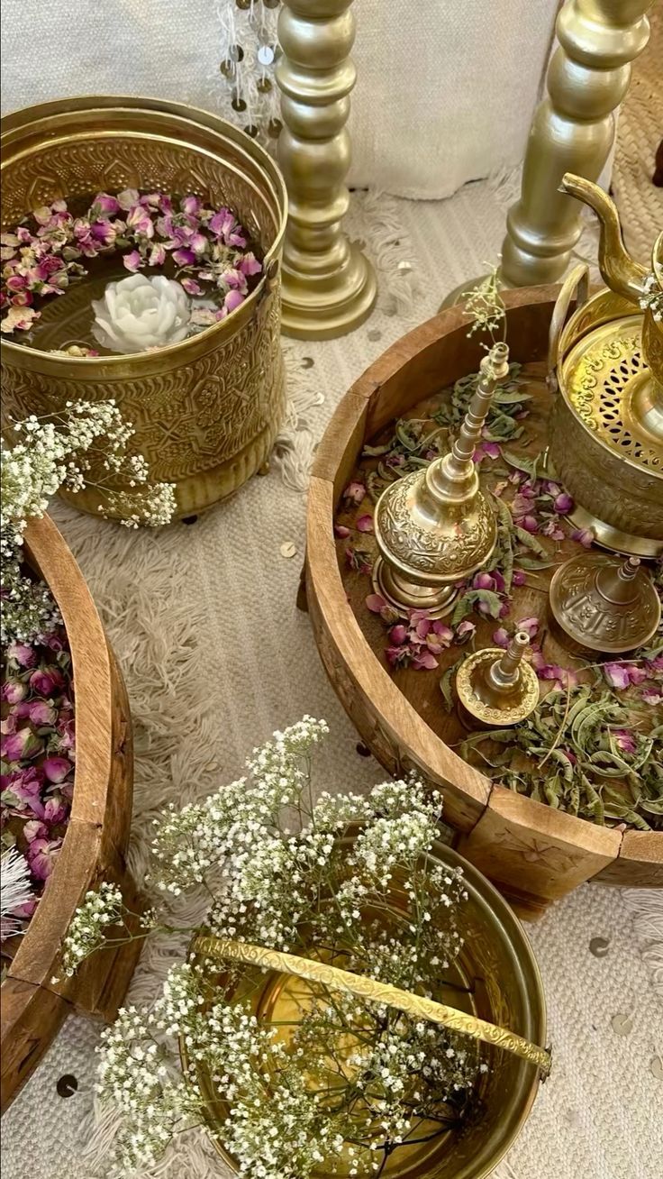 three wooden bowls filled with flowers and candles