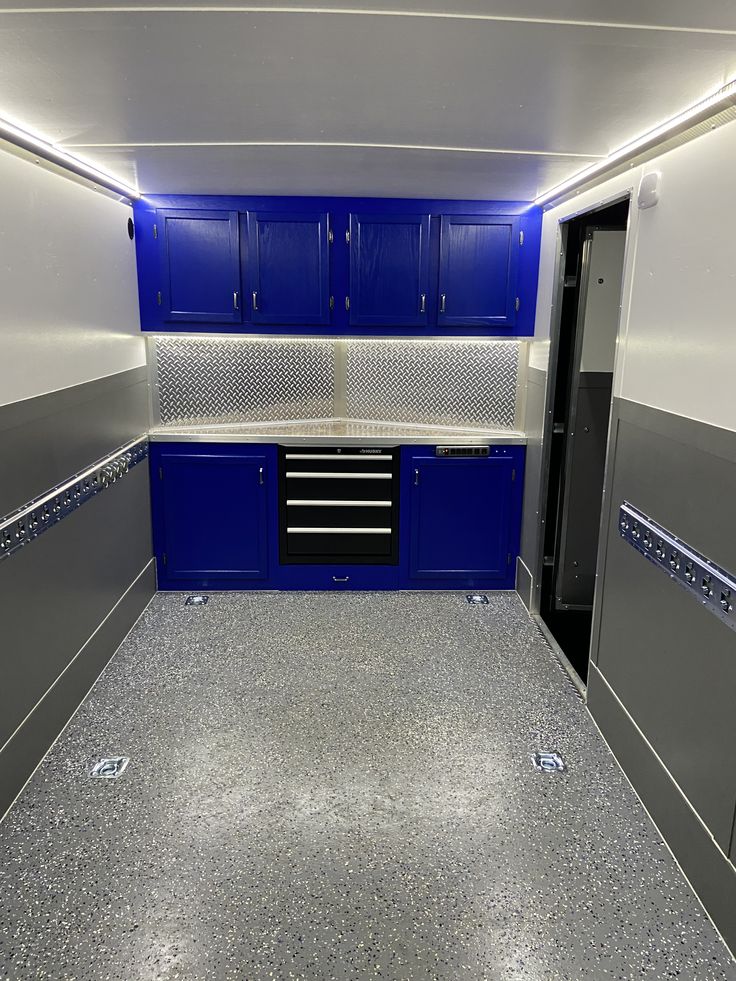 an empty garage with blue cabinets and silver flooring