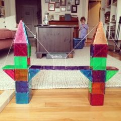 a child is playing in the living room with some colorful glass blocks that look like an airplane