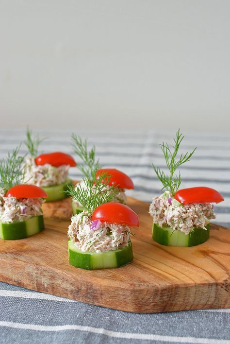 cucumber tuna salad bites on a cutting board with dill garnish