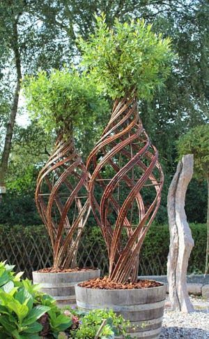 two metal sculptures sitting next to each other in a garden