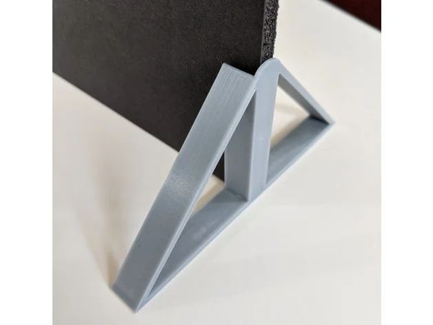 a black and white book holder with two triangulars on the front, sitting on a table