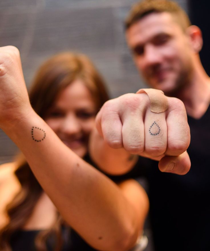 a man and woman are pointing their fingers at the camera