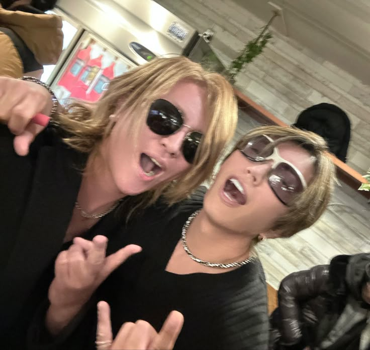 two women in sunglasses posing for the camera