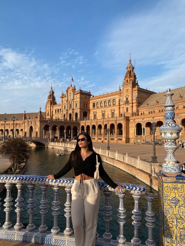 a woman standing on a bridge in front of a building