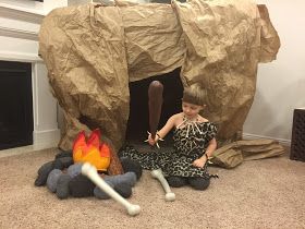 a woman sitting on the floor in front of a fake fire pit