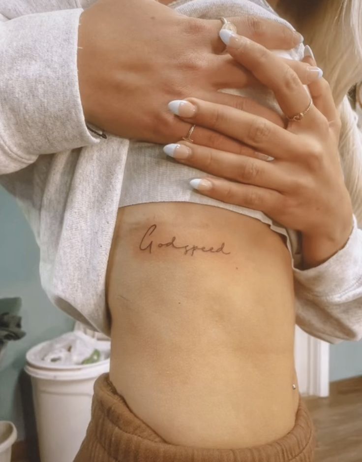 a woman holding her stomach with the word love written on it