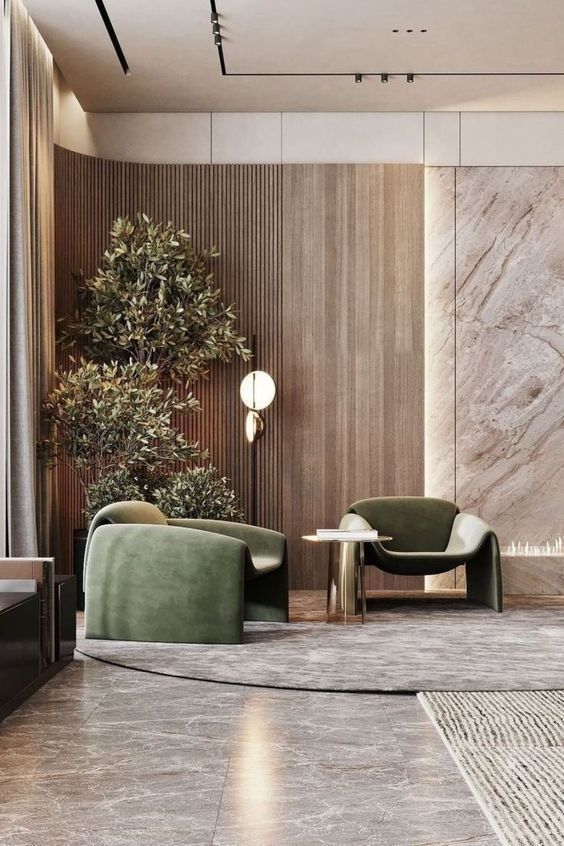 an elegant living room with two green chairs and a round coffee table in the center