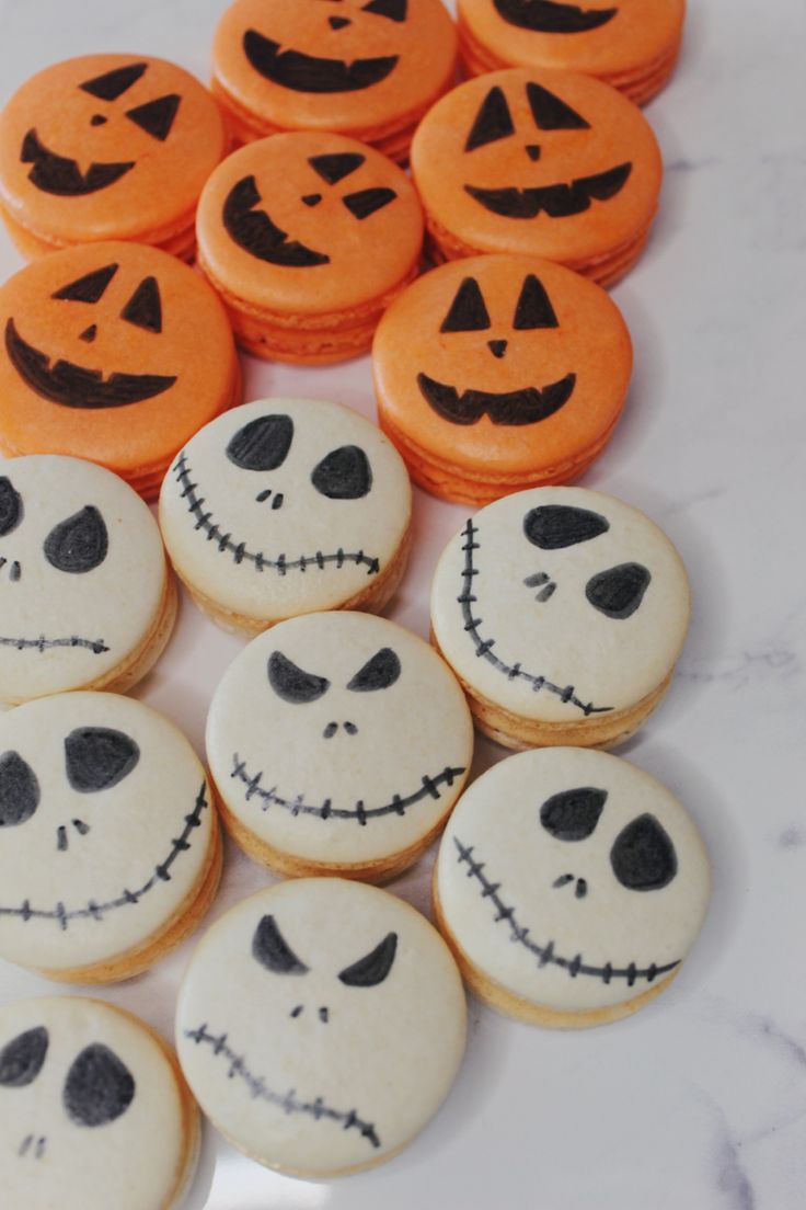 halloween cookies with jack - o'- lanterns and faces are arranged on a table