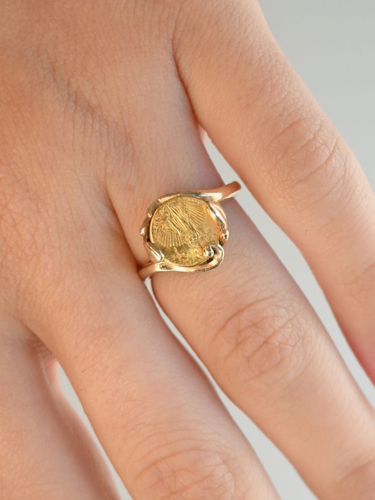 A beautiful coin ring with lots of vintage charm. The 18K coin sits in a 14K handmade mount accented with organic swirls and and curves, and was likely custom made for the original wearer. The band has wonderful buttery soft gold tones, while the coin has that extra pop of brightness thanks to the higher purity. "The Saint-Gaudens double eagle is a twenty-dollar gold coin, or double eagle, produced by the United States Mint from 1907 to 1933. The coin is named after its designer, the sculptor Au 14k Gold Coin-shaped Rings, Vintage 14k Gold Coin Ring, 14k Gold Coin Shaped Anniversary Rings, Gold Coin Ring, Double Eagle, Gold Coin Necklace, Coin Ring, Gold Coin, Coin Necklace