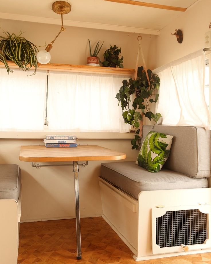 a small room with a table, couch and air conditioner