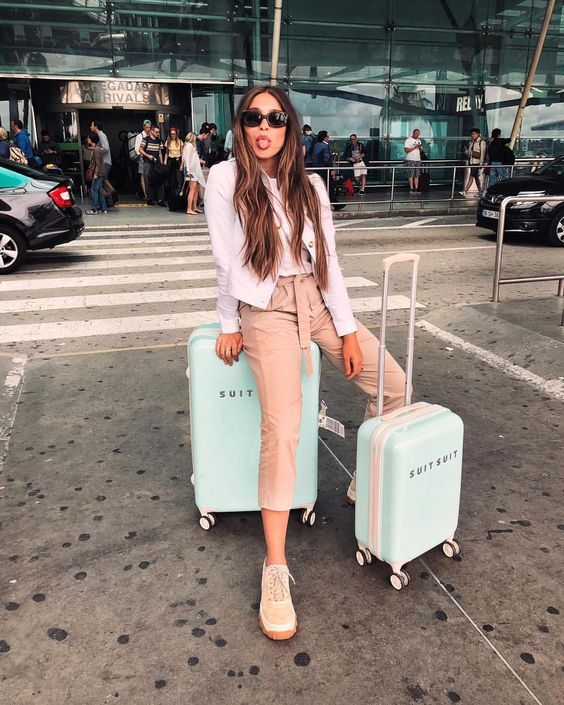 a woman sitting on top of two suitcases