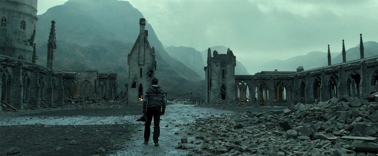 a person walking in the middle of an old ruin with mountains in the background at night