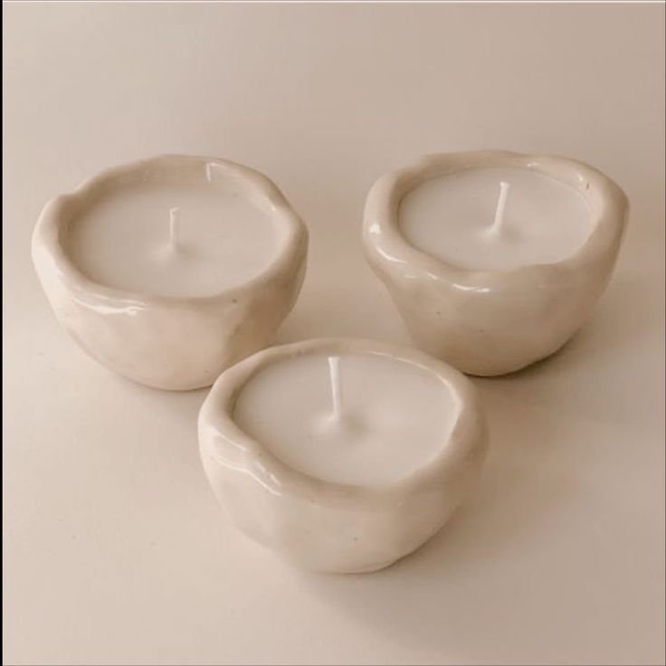 three white candles sitting next to each other