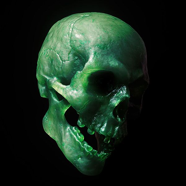 a green skull with its mouth open on a black background