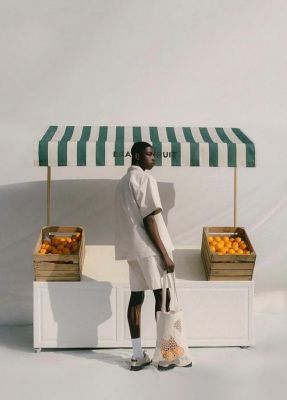 a man standing in front of a fruit stand