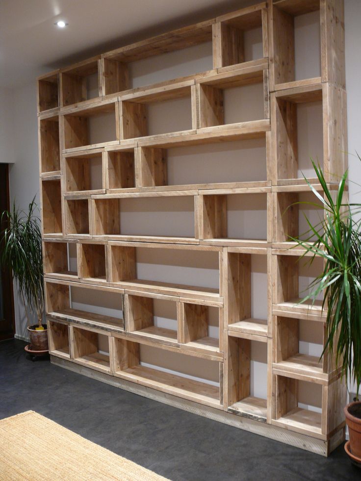 a large wooden book shelf sitting next to a potted plant