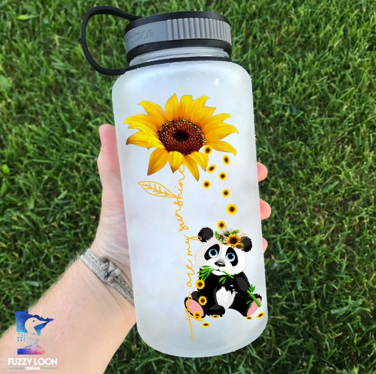 a hand holding a water bottle with a panda bear and sunflower on the side