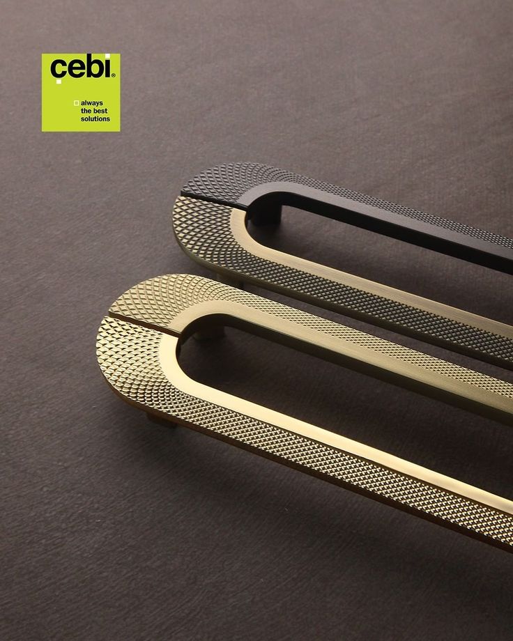 a close up of two metal handles on a black surface with a cebi logo in the background