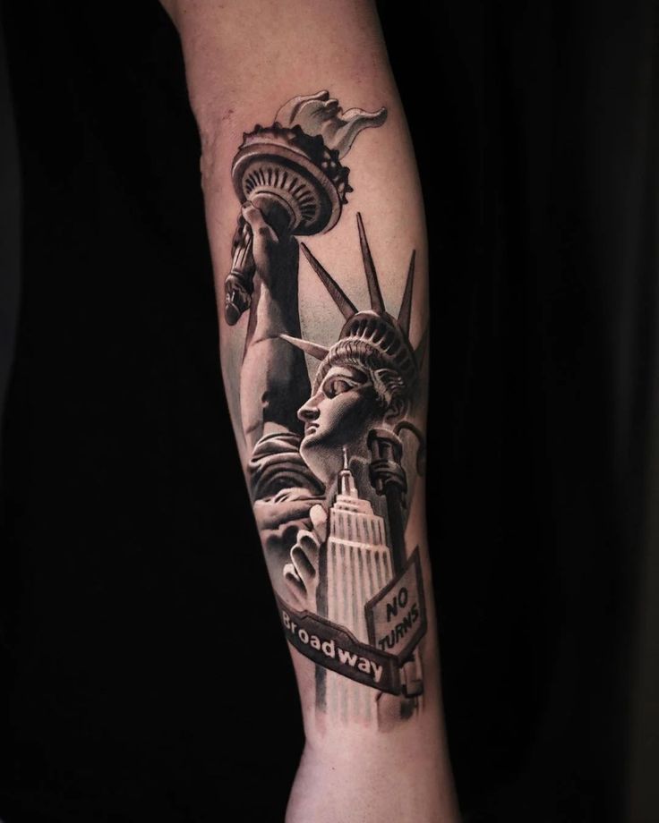 the statue of liberty tattoo on the right arm and left arm is black and grey