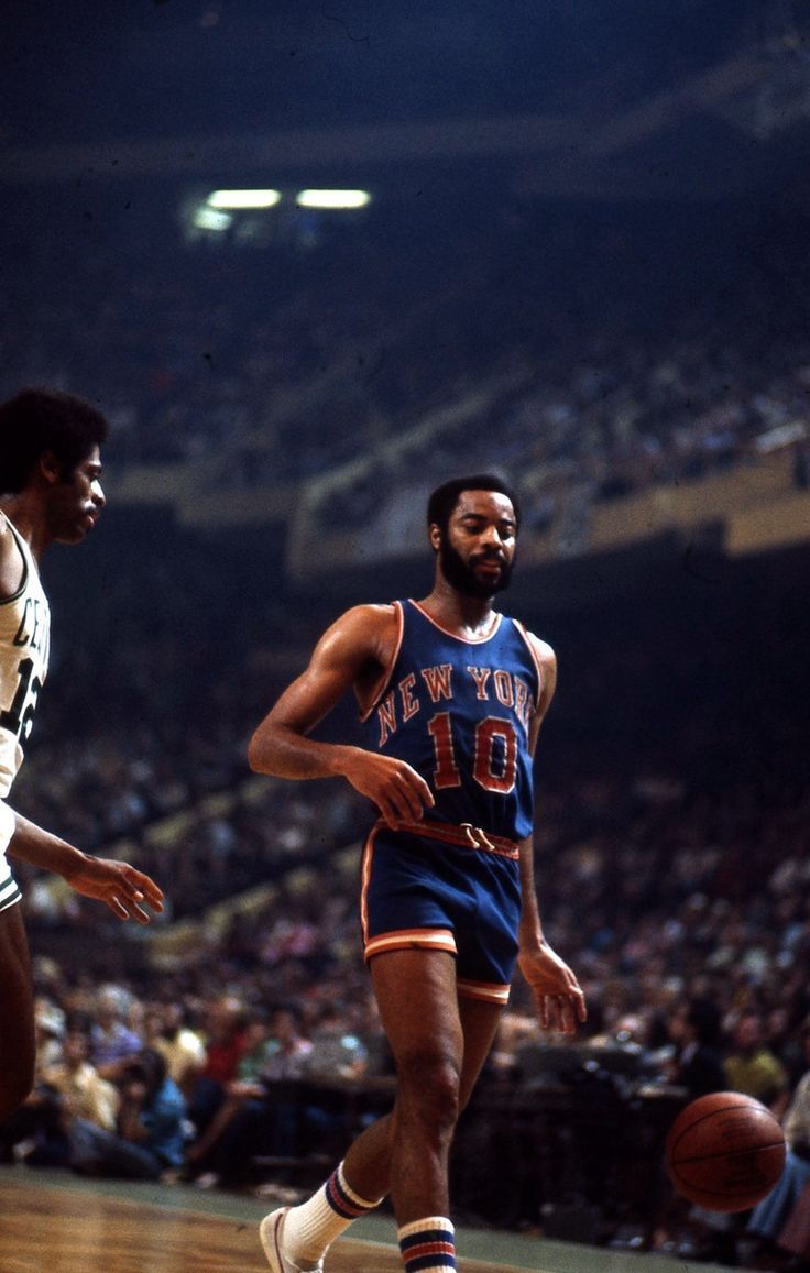 two basketball players in action on the court during a game with fans watching from the stands