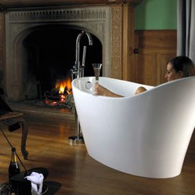 a woman sitting in a bathtub next to a fire place