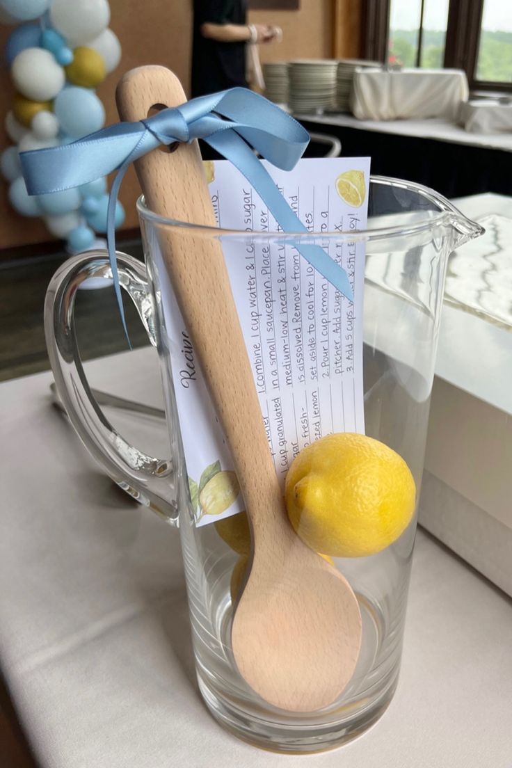 a wooden spoon sitting on top of a glass cup filled with lemons and paper